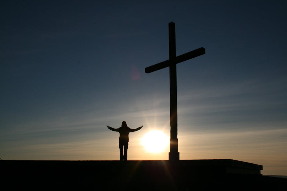 Silhouette of a person meditating during sunrise with soft light